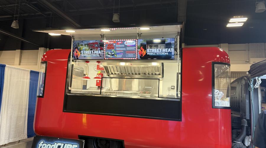 Rounded red food trailer with a large gull-wing service opening displayed at FTO Expo 2026